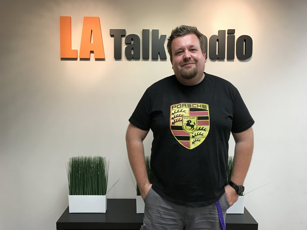 Guest standing beneath the LA Talk Radio sign