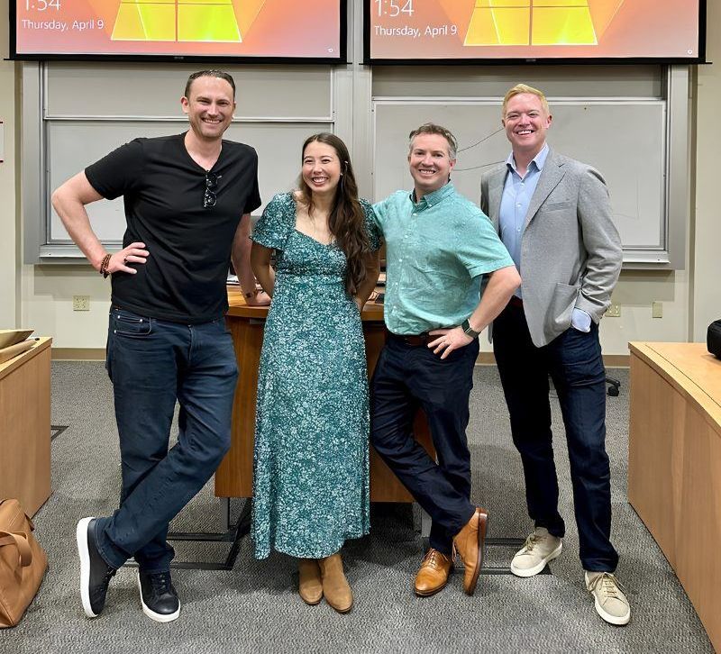 Four event speakers standing together in a classroom