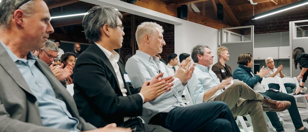 Investors applauding at a 1752vc pitch event.